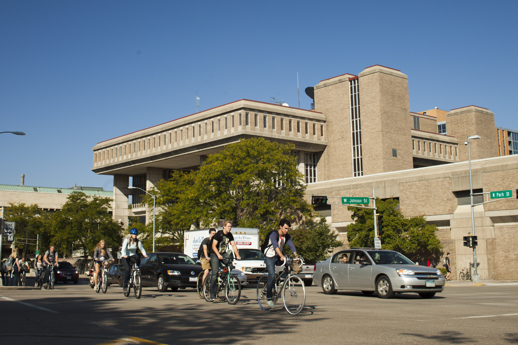 Cyclists and cars pass by Vilas Hall on a summer day.